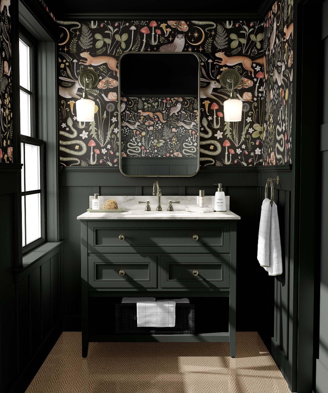 A moody powder room features black and floral patterned wallpaper, a dark green vanity with a white countertop, and a rectangular mirror flanked by lights above the sink, creating an ambiance inspired by nature.