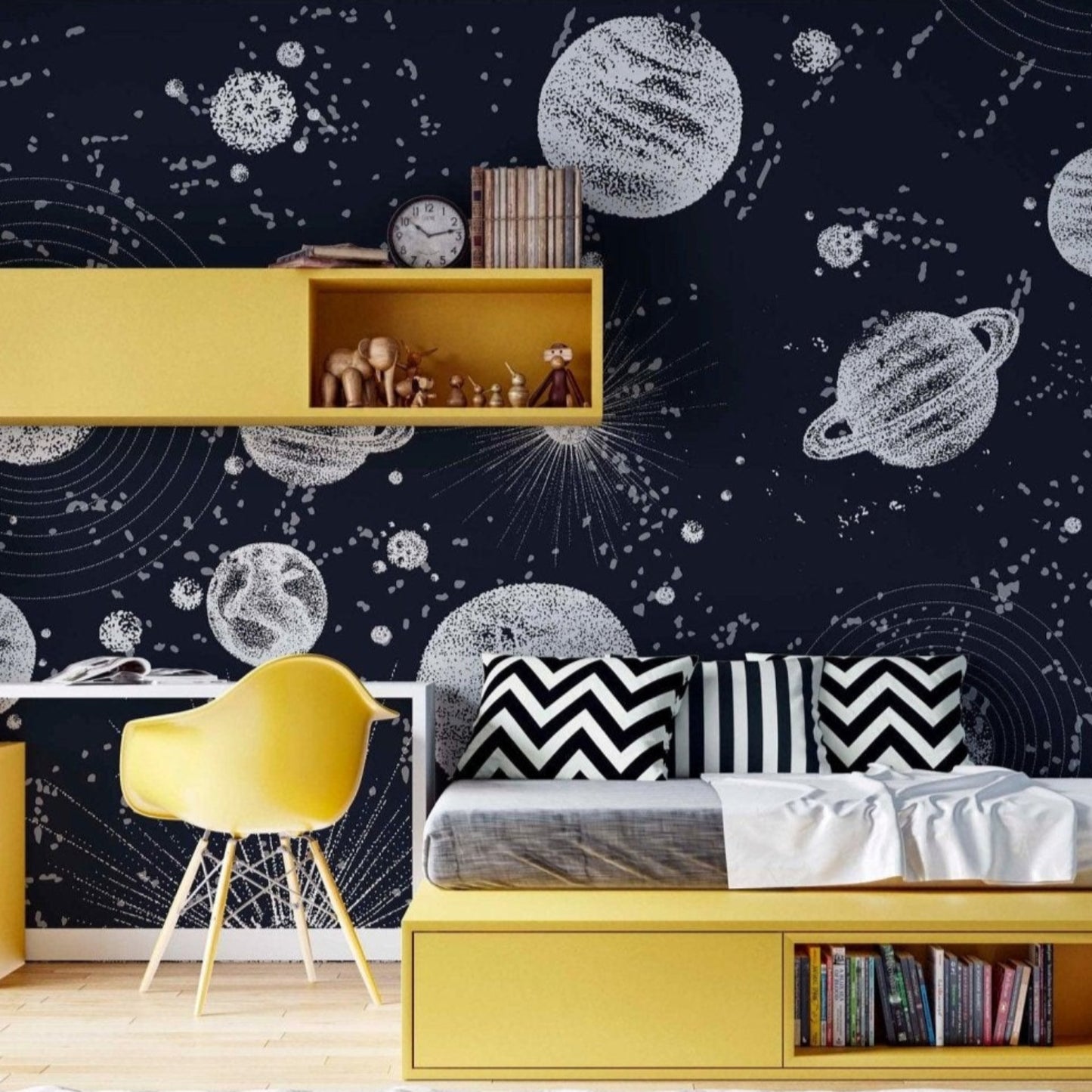 Planet wallpaper mural in a kids bedroom with yellow furniture that contrasts the deep navy blue background