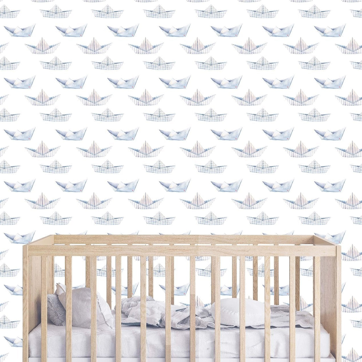A serene nursery showcasing white and blue wallpaper decorated with delightful paper boats, perfect for a baby's space.