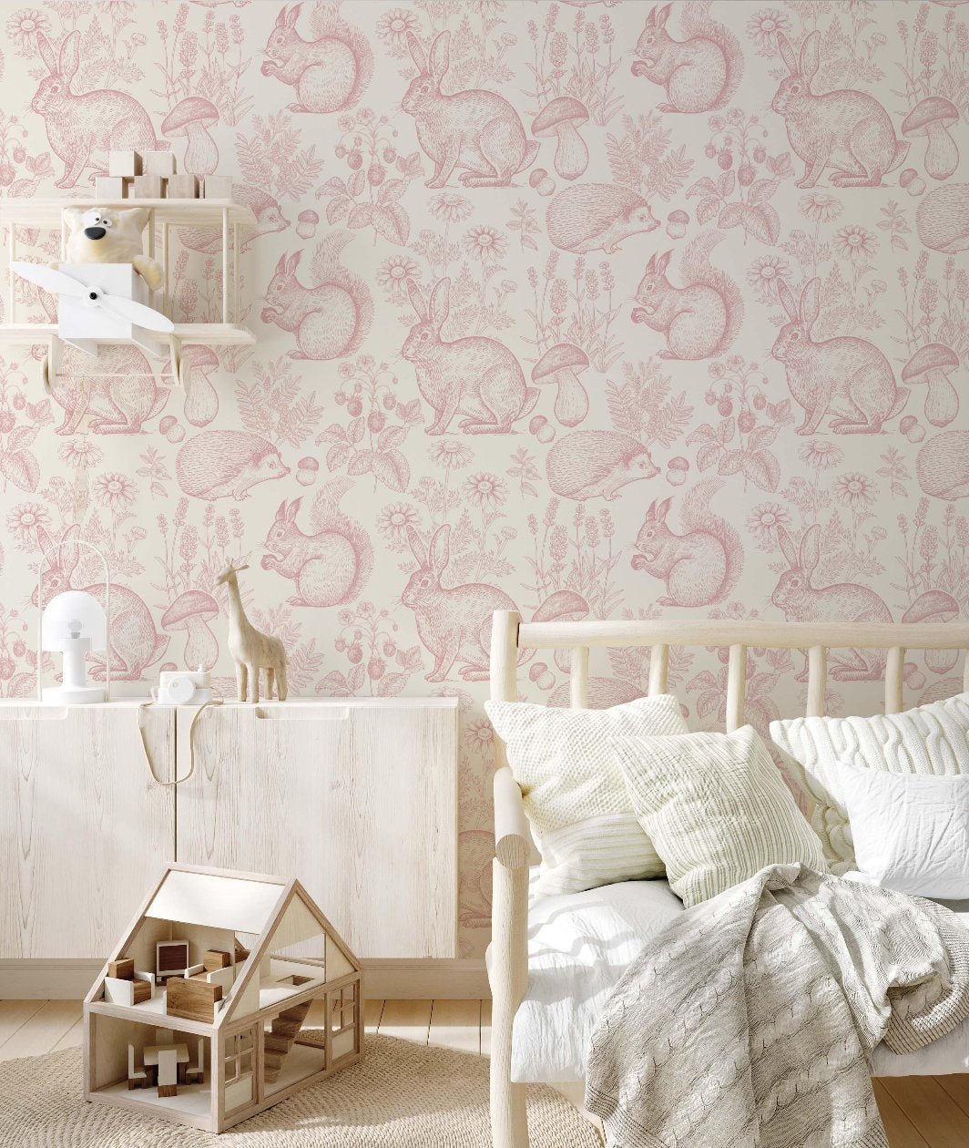 A vibrant children's room in pink and white, showcasing a bed, dresser, and an engaging wallpaper with forest animalsl for a playful environment.