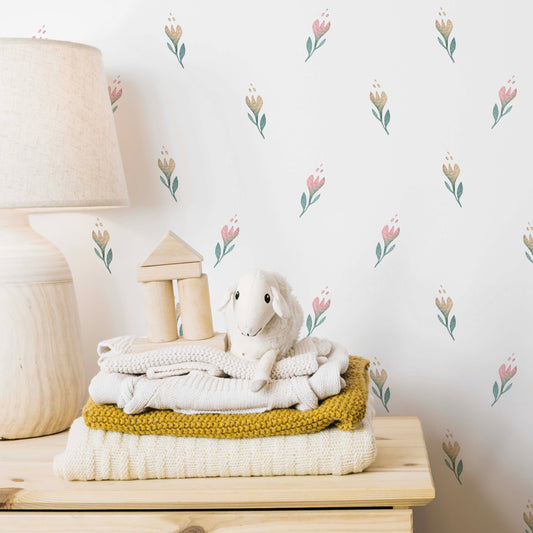 soft blossom floral wallpaper in nursery bedroom with a light wood chest of drawers