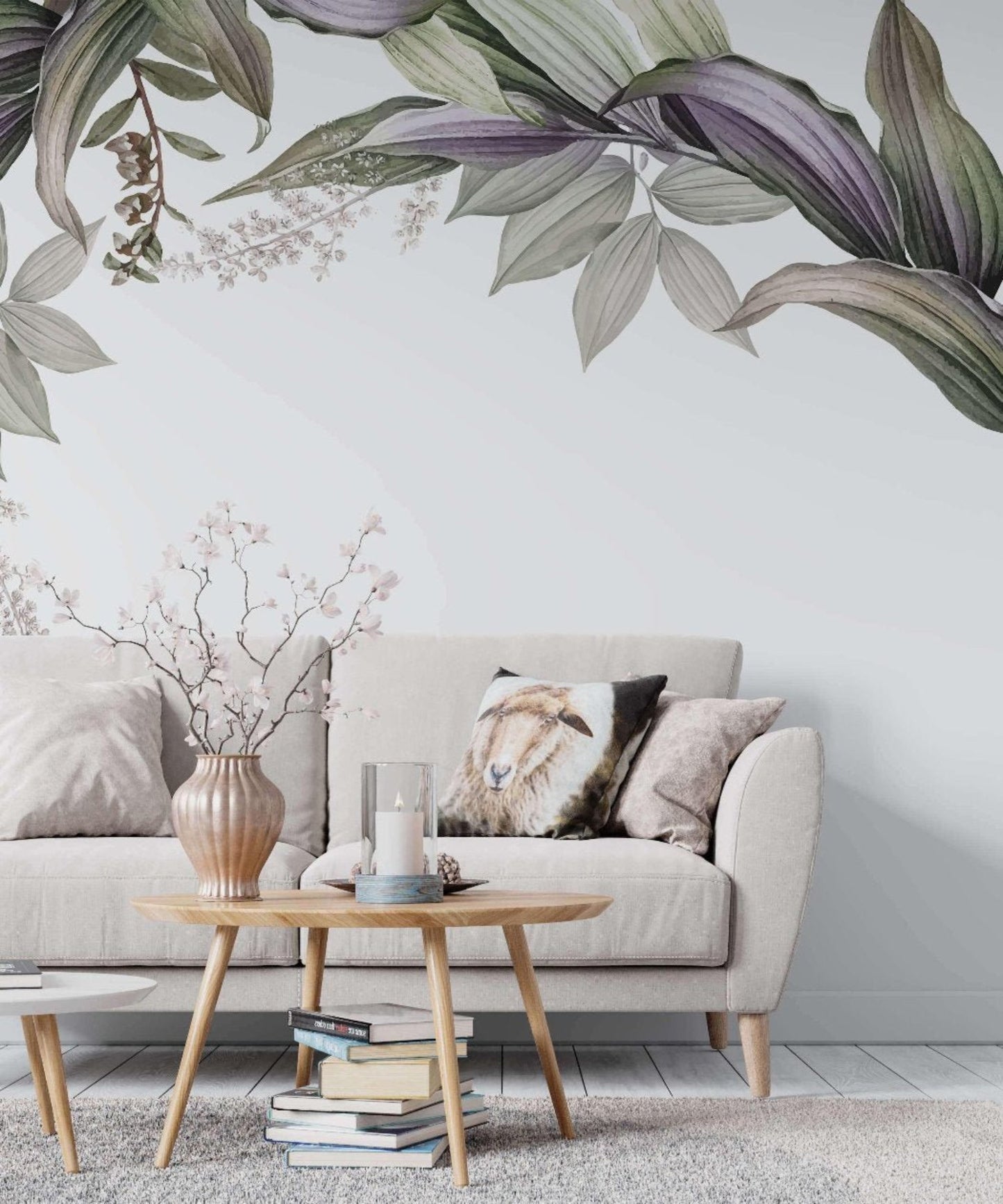 A living room with a couch, table and a tropical wall mural with green and purple leaves.