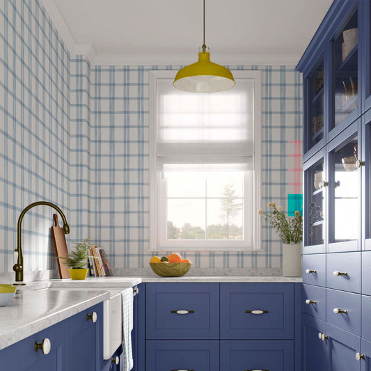 cat-615198490952 Modern kitchen and dining area featuring blue and white plaid wallpaper, navy blue cabinets with white knobs, a yellow pendant light, and a large window.
