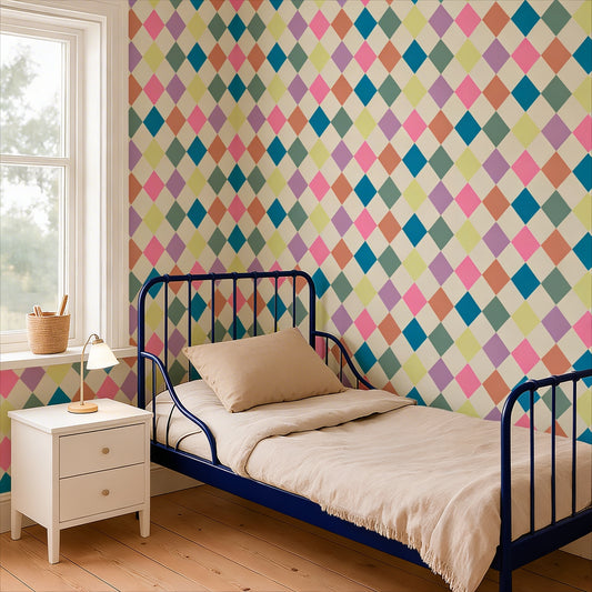 cat-616983200072 A cozy child's bedroom featuring a bold, multi-colored harlequin diamond pattern wallpaper in shades of pink, teal, purple, and yellow. A blue metal bed frame with beige bedding sits against the wall, next to a white nightstand and a bright window.