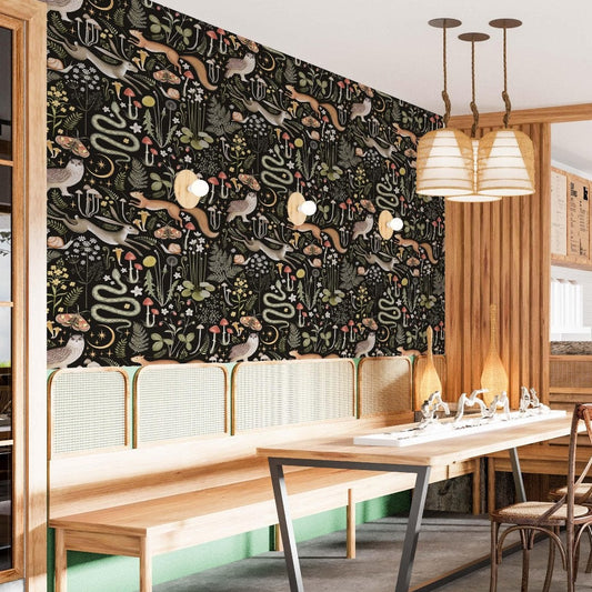 cat-659356549448 Dining Room with rustic decor and a moody atmosphere, featuring a wooden table and chairs, hanging  lamp, and wallpaper with nature motifs—squirrels, snakes, and mushrooms—perfect for those who appreciate the cottagecore aesthetic.