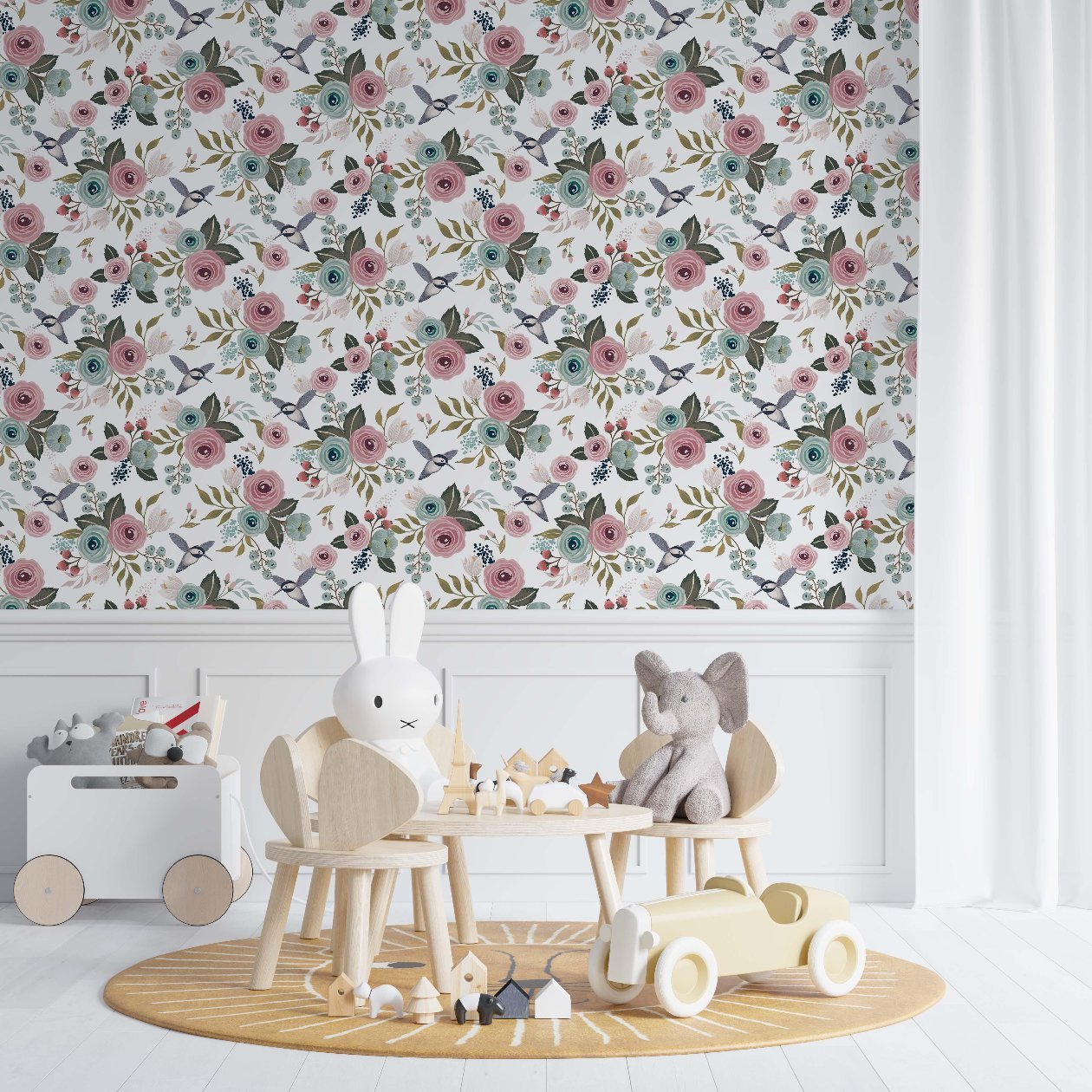 Nursery room with vintage floral wallpaper featuring pink and blue flowers and small birds on the wall above wooden children's furniture and toys.