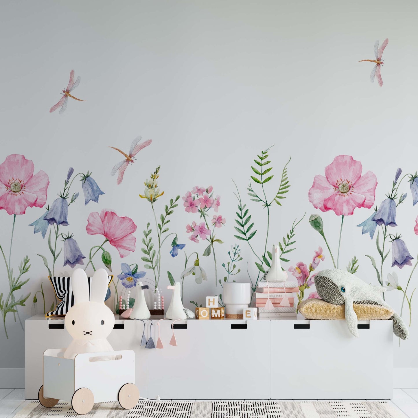 Watercolor wallpaper mural featuring a summer meadow with pink poppies, bluebells, green ferns, and delicate dragonflies over a white background in a kids' nursery.