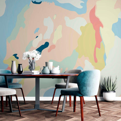 Contemporary dining room interior featuring a large abstract pastel wall mural behind an oval table and velvet chairs
