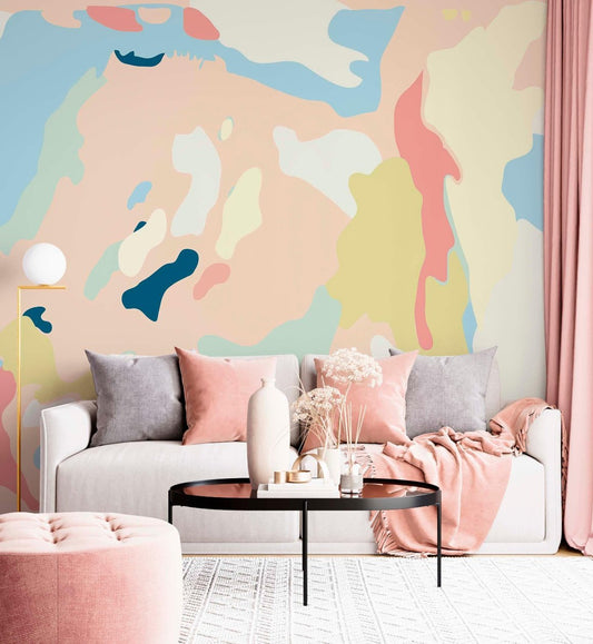 Modern living room interior featuring an abstract pastel wall mural behind a white sofa with pink and grey cushions.
