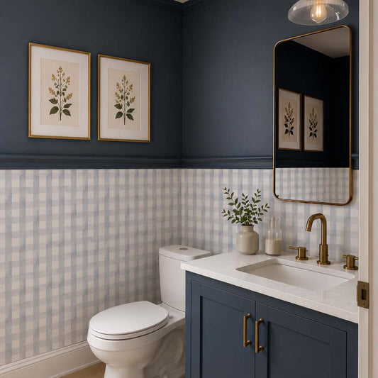 Modern powder room with blue grey gingham wallpaper, navy blue walls, matching blue vanity, brass fixtures and light wood flooring.