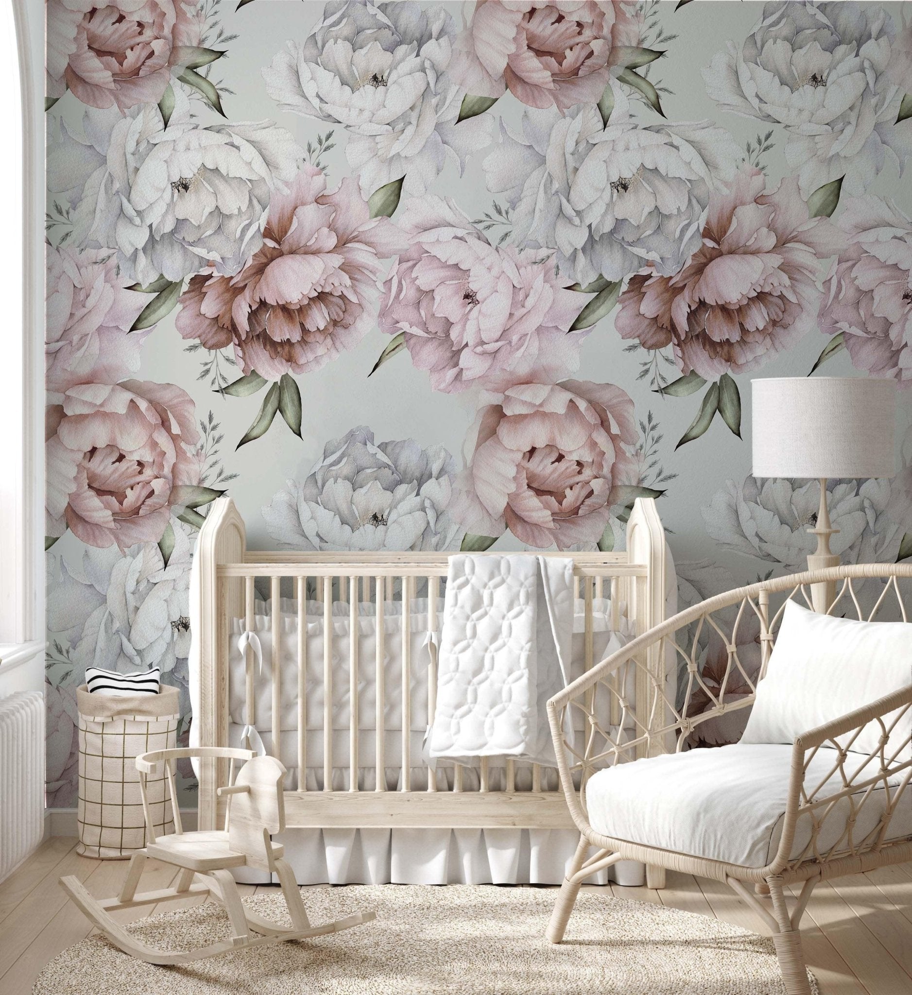 cat-615198294344 A bright  nursery bedroom featuring a large-scale floral wallpaper with watercolor peonies in shades of blush pink, dusty rose, and white. The botanical accent wall serves as a backdrop for a light wood crib and a rattan chair, creating a soft, romantic, and bohemian atmosphere.