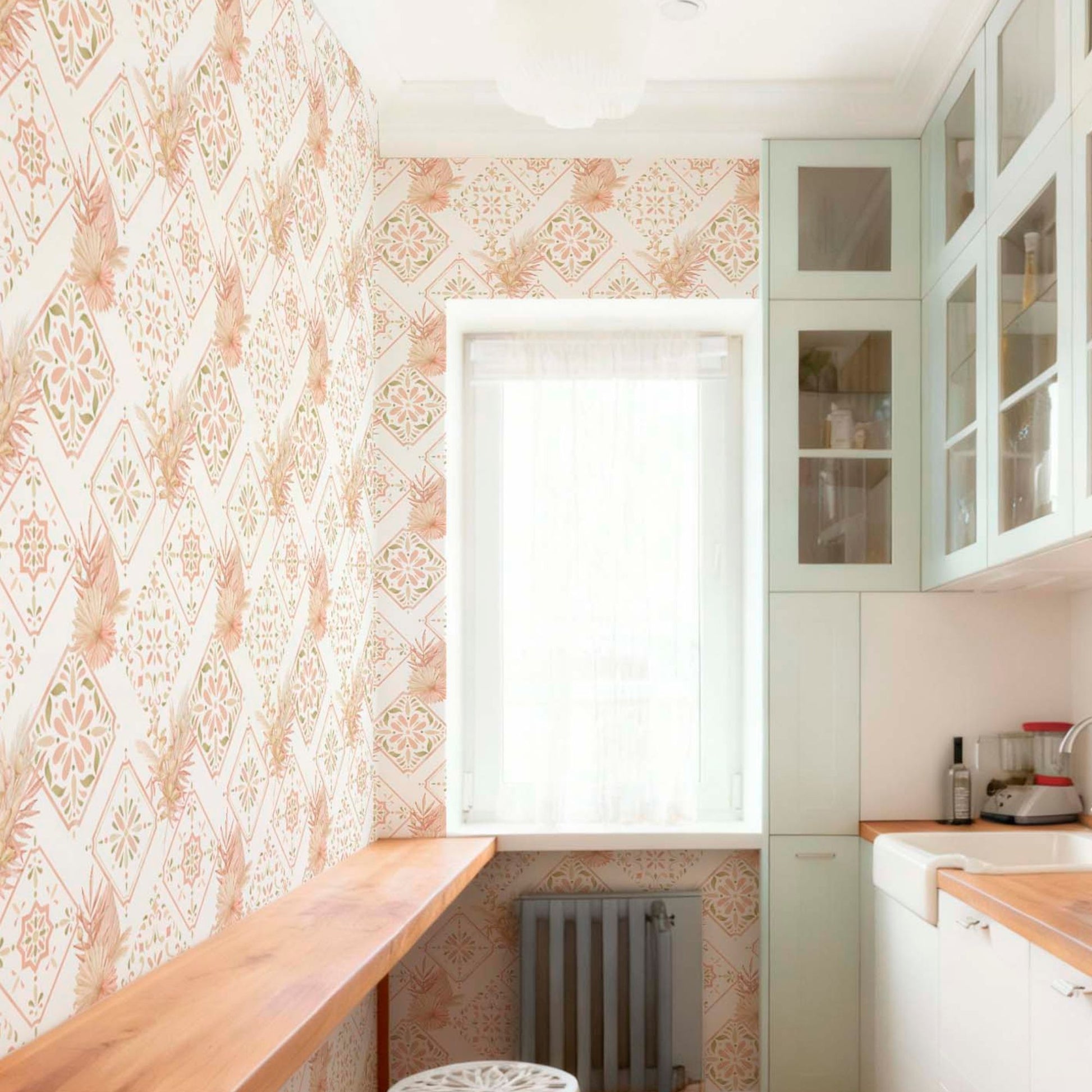 cat-615198490952 Narrow kitchen with geometric floral wallpaper, light mint green cabinets with glass doors, a wooden countertop, and a bright window with a sheer curtain.
