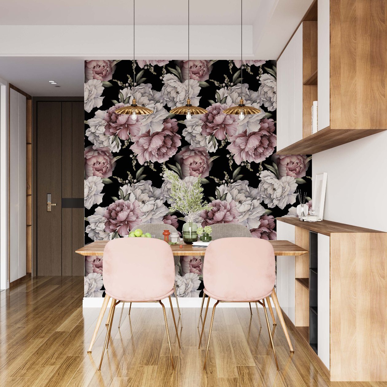 Dining area with a bold floral wallpaper featuring large pink and white peonies against a black background. The space includes a wooden dining table with two soft pink chairs, pendant lights with gold accents, and wooden shelving units on the right. The light wood flooring and neutral furniture provide a modern contrast to the striking floral wall design.