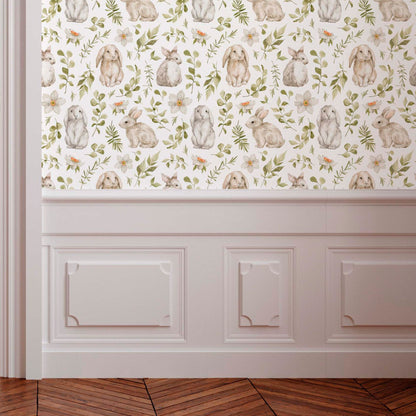 Whimsical wallpaper with hand-painted bunnies and green leaves above white wall molding and a chevron wood floor.
