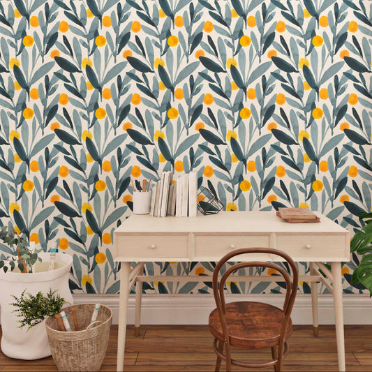 cat-610804433224 A desk with books and a chair in front of a colorful leaf-patterned wallpaper, next to a window with blinds and a potted plant.