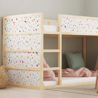 Kura bed with colorful dot decals in a children's bedroom, featuring cozy bedding, decorative pillows, and a small wooden table with chairs.