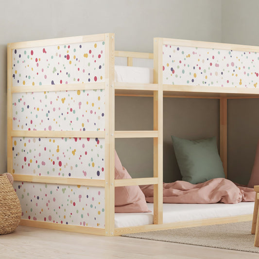 Kura bed with colorful dot decals in a children's bedroom, featuring cozy bedding, decorative pillows, and a small wooden table with chairs.