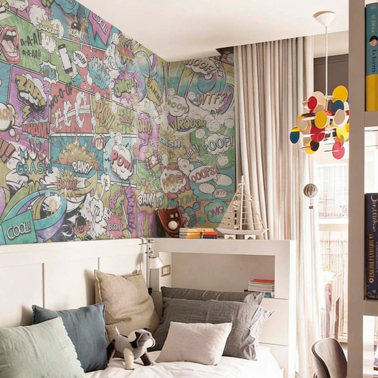 A vibrant teen bedroom featuring a comic-book-style mural with colorful speech bubbles and action words, a white bed with multiple gray and blue pillows, and a playful multi-colored hanging light fixture.