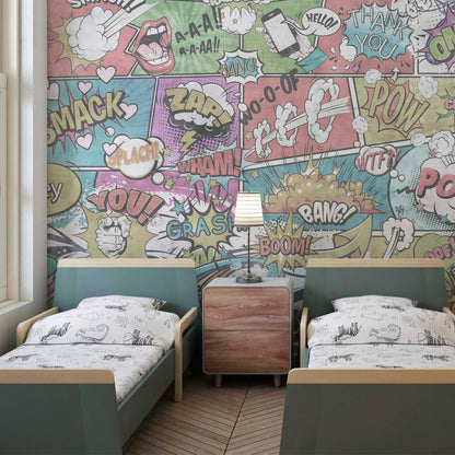 A children's bedroom featuring twin beds with teal headboards and a comic book-style mural background with colorful action bubbles and sound effects.