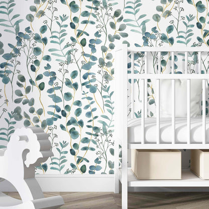 cat-615198294344 A bright nursery featuring a teal and white botanical wallpaper with watercolor eucalyptus leaves as an accent wall. A white wooden crib with neutral storage bins underneath is positioned against the wall, accompanied by a white wooden rocking horse in the foreground. The room has light wood flooring, creating a calm and modern aesthetic for a baby's room.