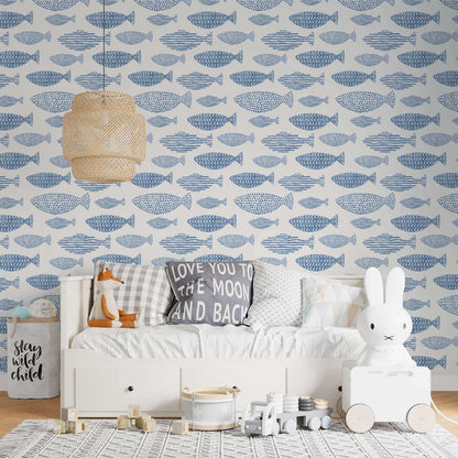 Children's room featuring a light-colored bed, woven lamp, and aquatic-themed wallpaper.