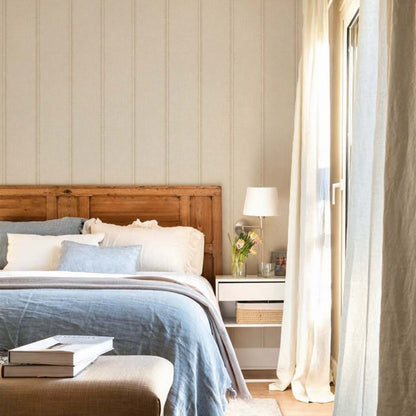 cat-616983200072 Bedroom with beige striped wallpaper behind a rustic wooden headboard and blue linen bedding