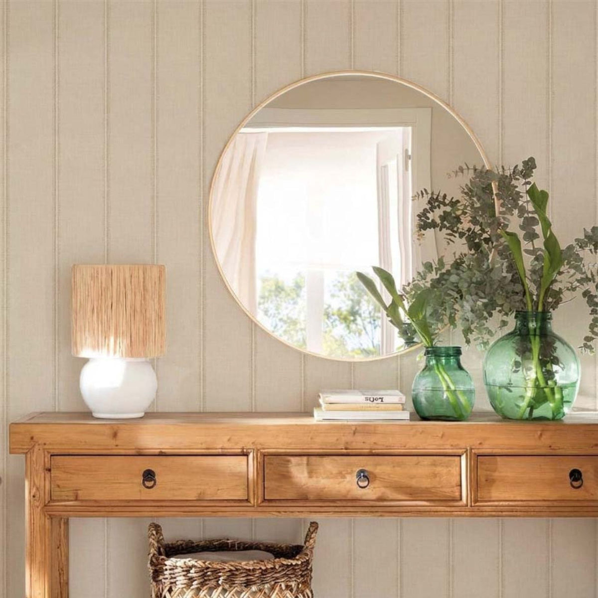 cat-659356549448 Entryway with French Linen Stripe wallpaper, pine console table, round mirror and green glass vases