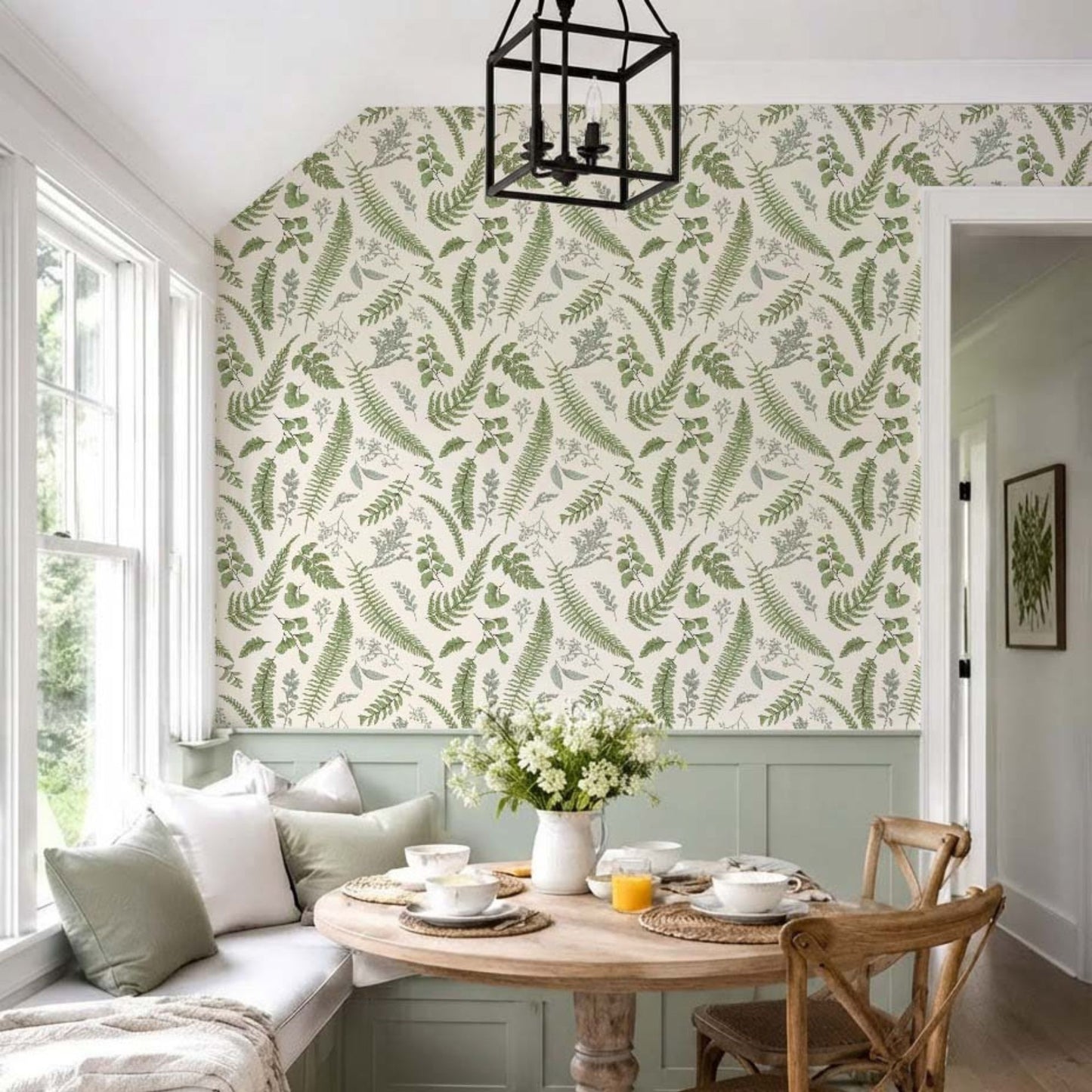 cat-659356549448  Botanical fern wallpaper in a bright breakfast nook with sage green bench seating, a round wooden table, and natural light.