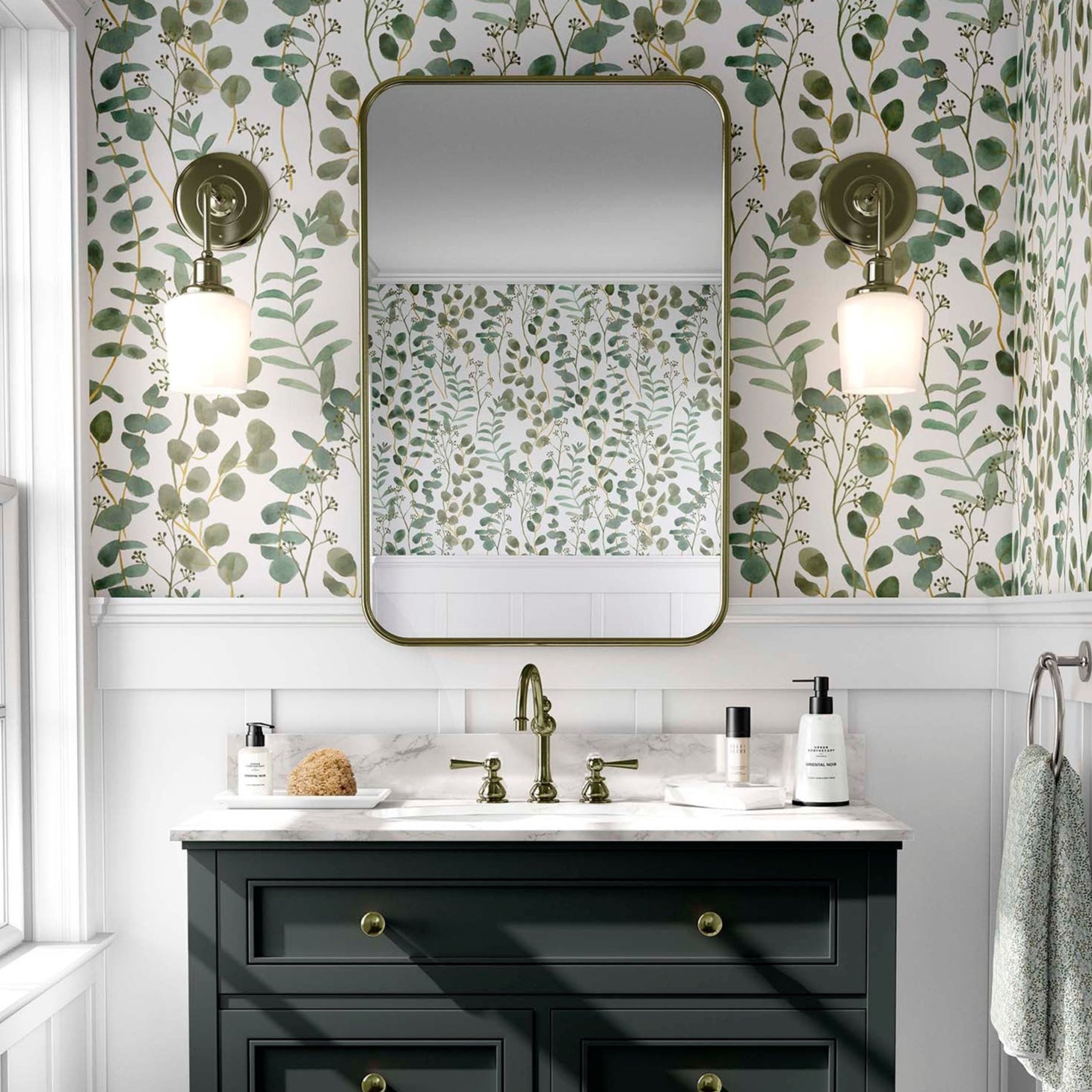 cat-610804236616 Modern bathroom with green eucalyptus watercolor wallpaper, a black vanity, and a brass-framed mirror.
