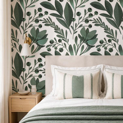 cat-616983200072 Green botanical wallpaper in a cozy bedroom with upholstered bed, oak nightstand and sage green bedding.