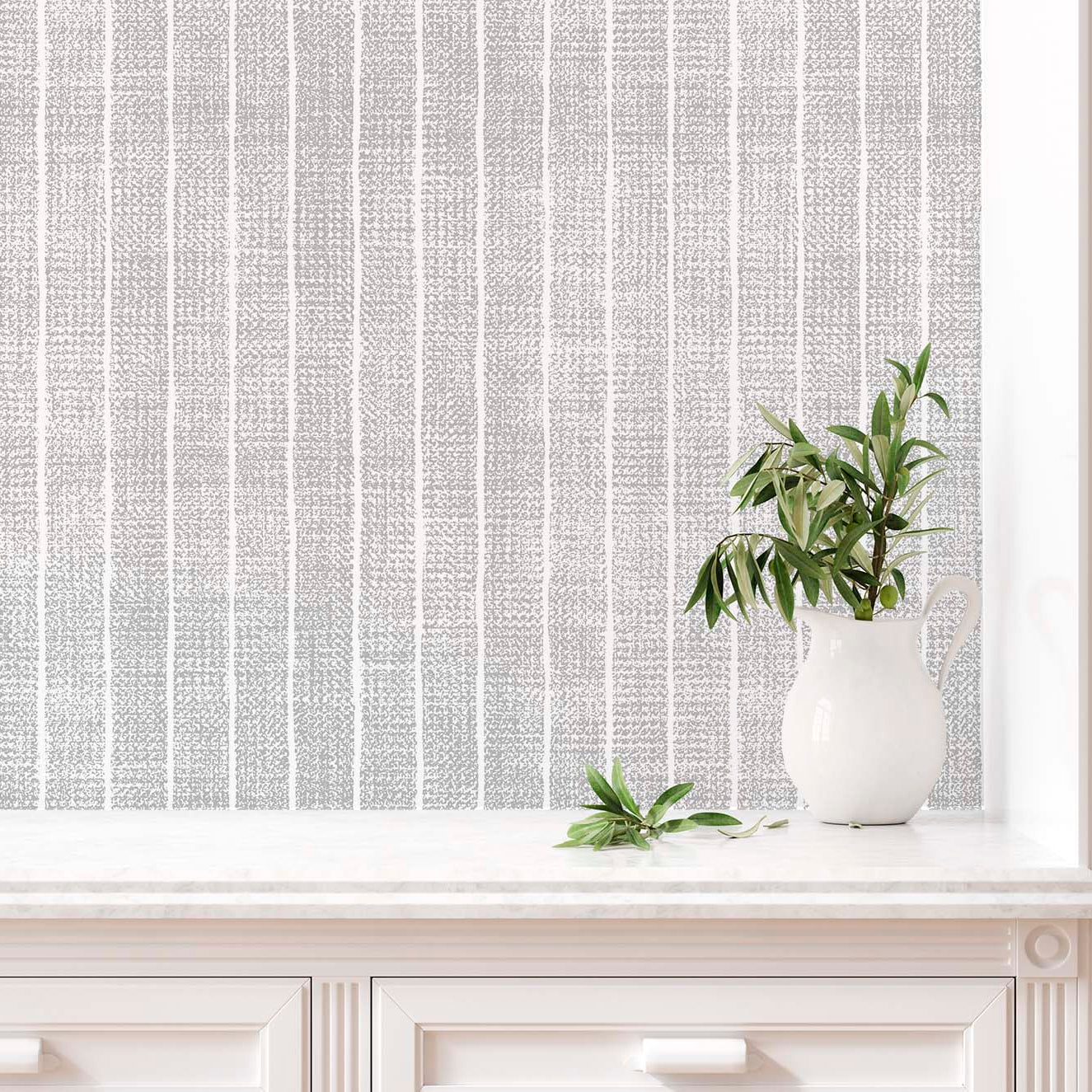 cat- 659356549448 Close-up of a grey and white textured stripe wallpaper above a white marble countertop with a white ceramic pitcher holding olive branches.