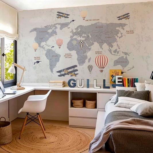 Grey world map wallpaper mural with hot air balloons and vintage planes in a teen bedroom with white desk, Eames chair and rattan rug