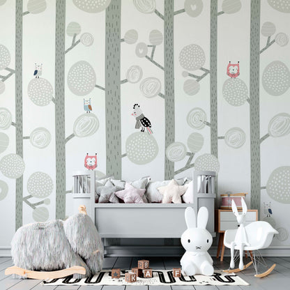 Happy Forest illustrated woodland mural in a Scandinavian nursery with gray bed and soft pastel decor