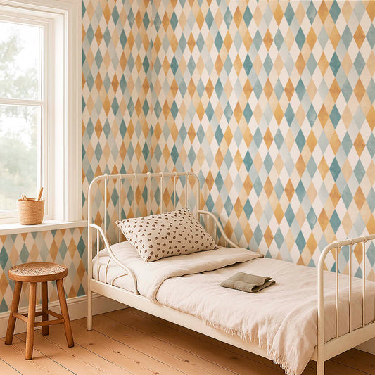 cat-616983200072 Geometric harlequin wallpaper with a watercolor diamond pattern in teal, ochre, and beige, featured on a kids bedroom wall behind a white metal bed and wooden floors.