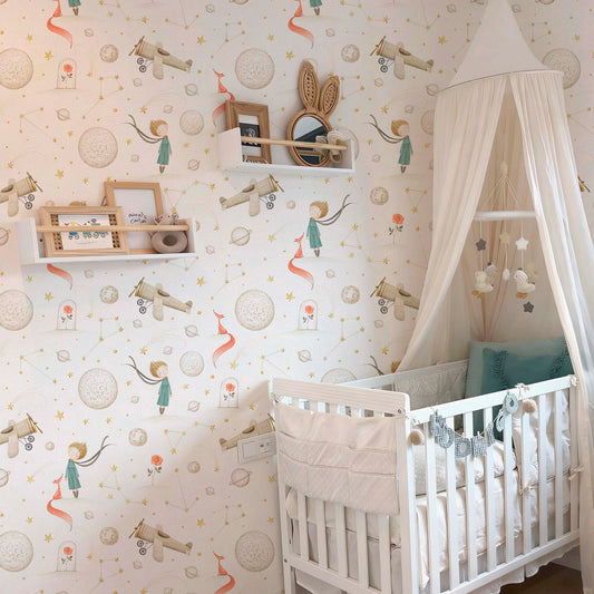 Cozy nursery with Little Prince wallpaper featuring watercolor planets, stars, and airplanes, styled with a white crib and soft canopy