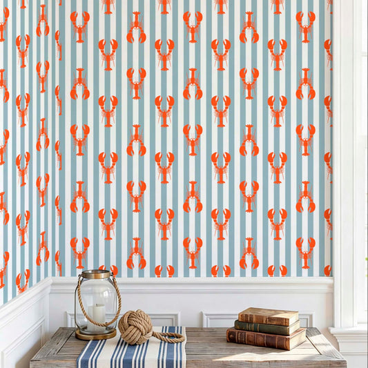  cat-659356549448 Close-up of  an entrance hallway with a nautical wallpaper with red lobsters on light blue stripes, styled with vintage books and marine decor.