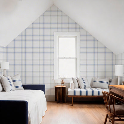 cat-616983200072 A bright, modern attic bedroom featuring a blue and white plaid accent wall, a low daybed with striped pillows, and a window centered under the sloped