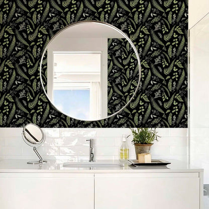 cat-610804236616 Contemporary bathroom featuring black wallpaper with green and white fern patterns, a large circular wall mirror reflecting a window, and white subway tiles above a sleek white vanity with a chrome faucet.