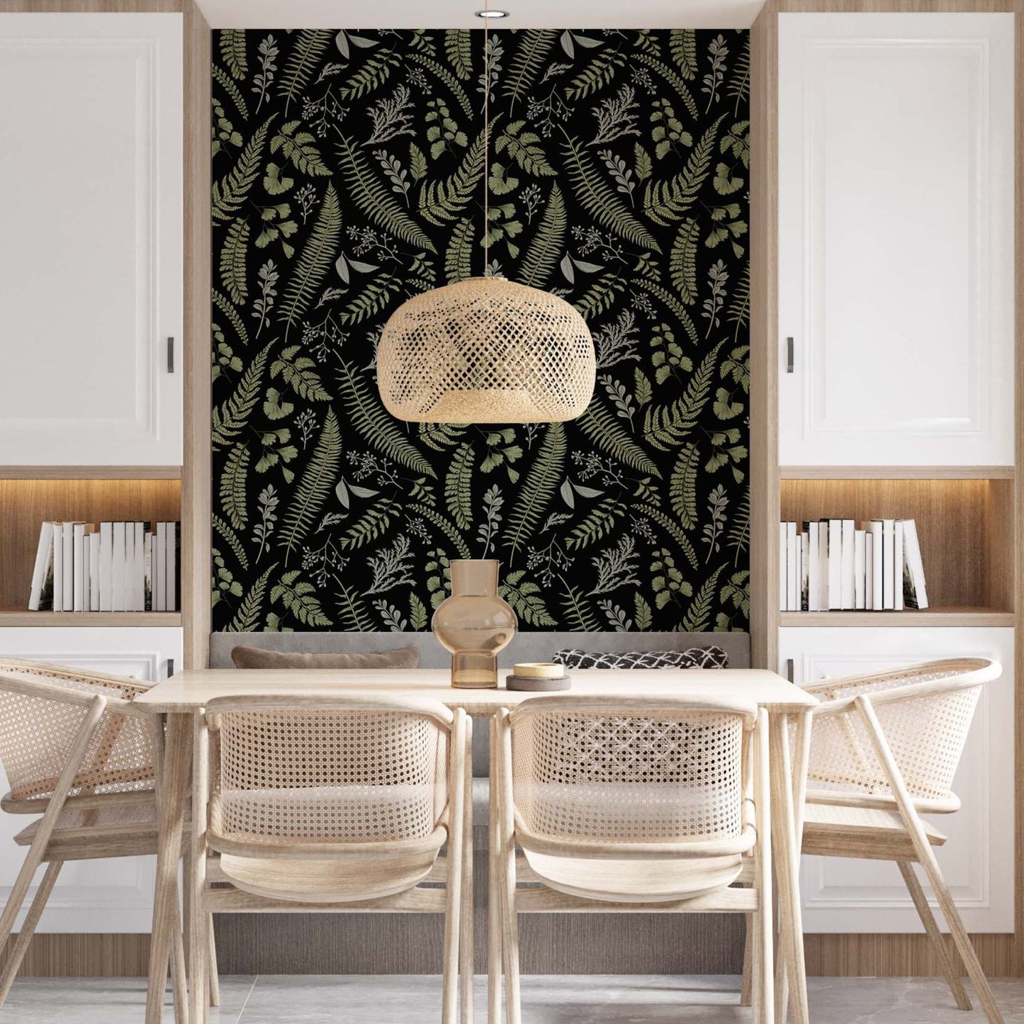 Modern dining room featuring an accent wall with black and green fern wallpaper, a light wood table with four woven rattan chairs, a wicker pendant light, and white built-in cabinets with integrated bookshelves.