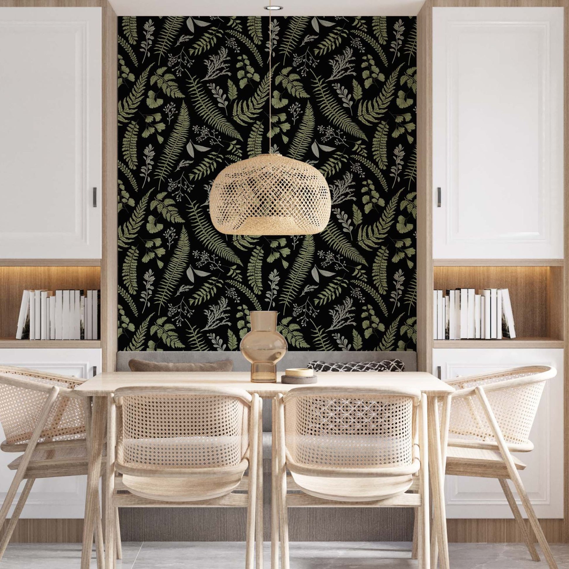 Modern dining room featuring an accent wall with black and green fern wallpaper, a light wood table with four woven rattan chairs, a wicker pendant light, and white built-in cabinets with integrated bookshelves.