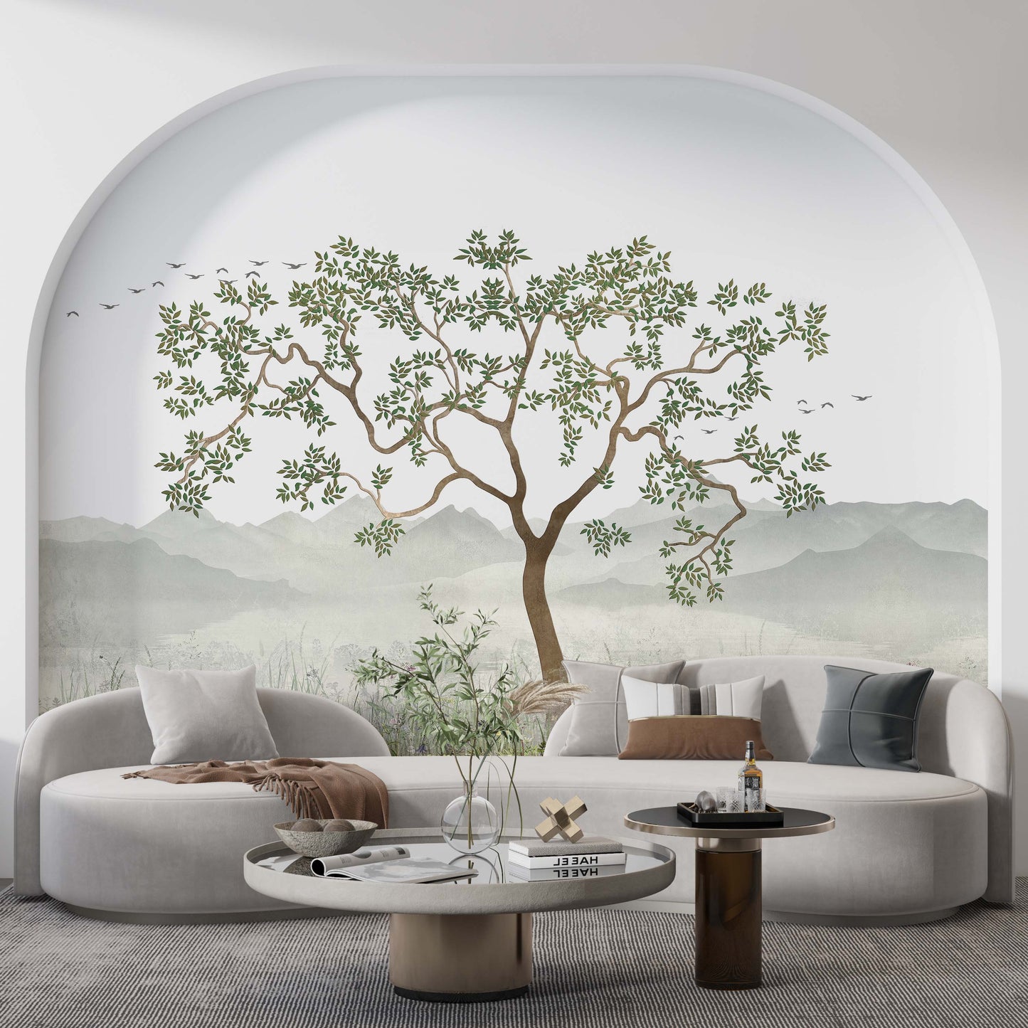 cat-610569683272  A stylish living room featuring a scenic nature wallpaper mural with a large tree inside a large wall arch behind a curved sofa.