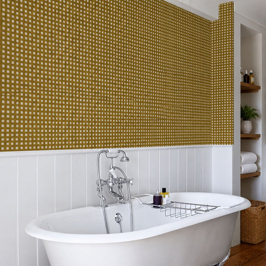 cat-610804236616 Mustard wallpaper with a hand-drawn checkered pattern in a traditional bathroom with white wall panelling.