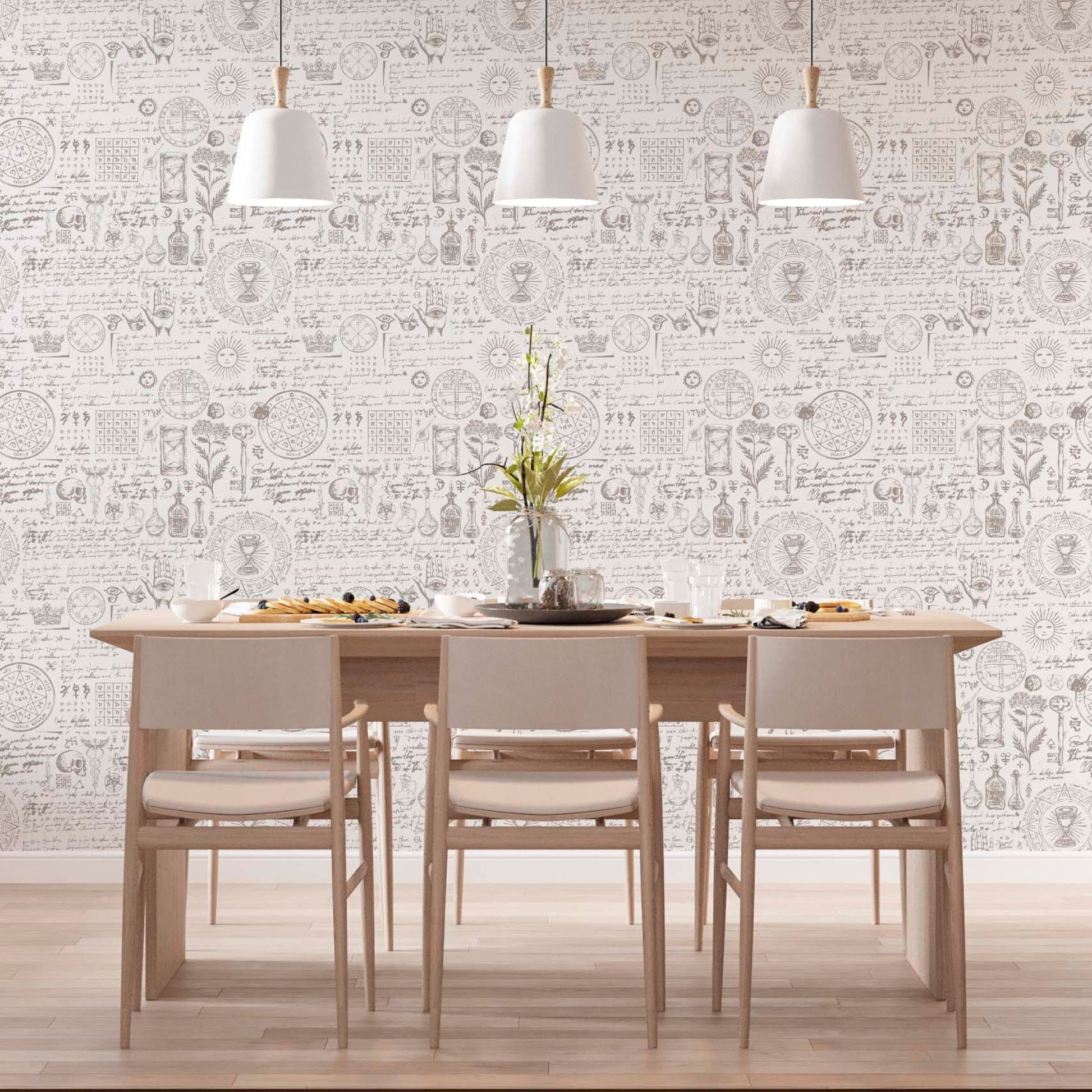 cat-659356549448  Modern dining room with a light wood table and chairs featuring vintage alchemy manuscript wallpaper with botanical sketches, sun symbols, and esoteric Latin text under three white pendant light