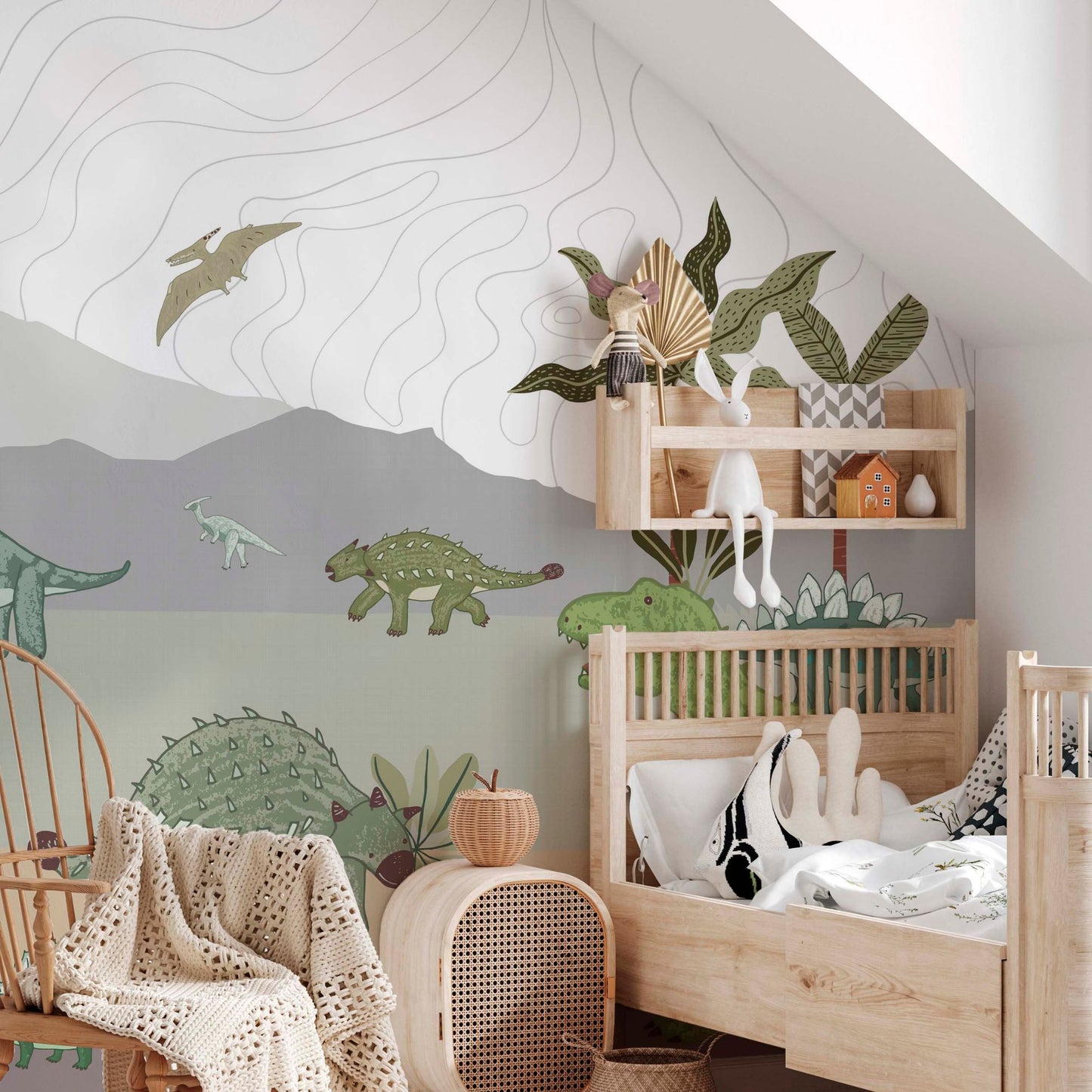 Cozy nursery with a dinosaur-themed wall mural, wooden crib, soft toys, wall shelf decor, and natural-toned furniture.