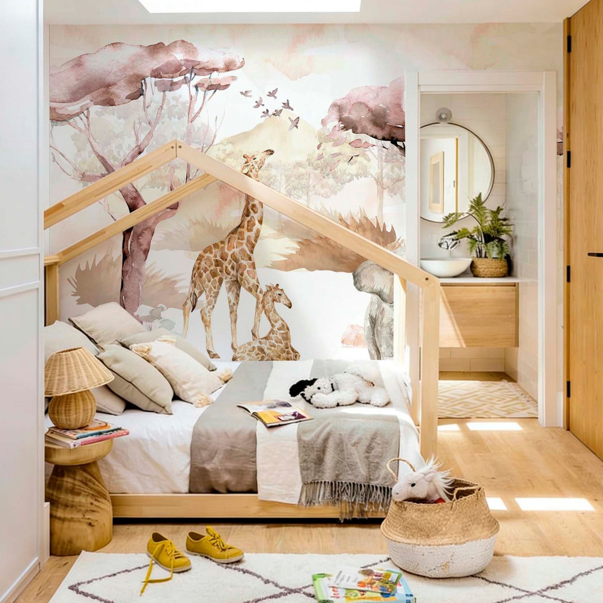 cat-661212758344 A children's bedroom featuring a safari watercolor wallpaper mural with giraffes behind a wooden house-shaped Montessori bed, styled with a plush rug and wicker baskets