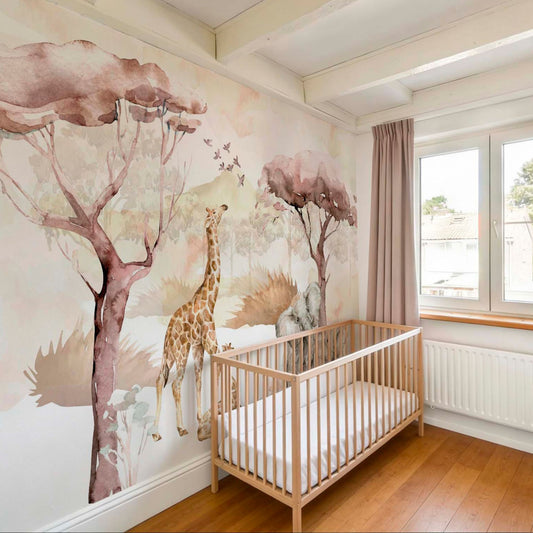 A nursery room featuring a safari-themed watercolor wallpaper mural with a giraffe and elephant behind a light wood crib, complete with dusty pink curtains and wooden flooring