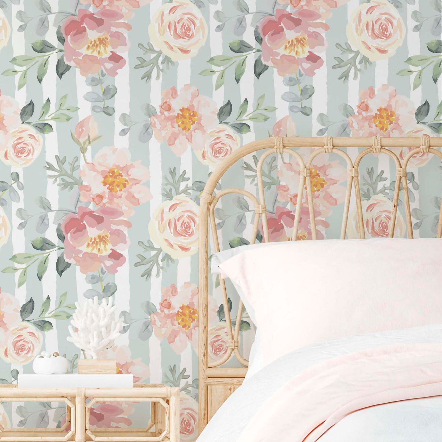 cat-616983200072 A bright and airy bedroom featuring a wall covered in sage green and white vertical striped wallpaper adorned with large, hand-painted watercolor pink peonies and cream roses. A light natural rattan headboard sits against the wall, topped with crisp white and soft pink bedding for a romantic, vintage-inspired look.