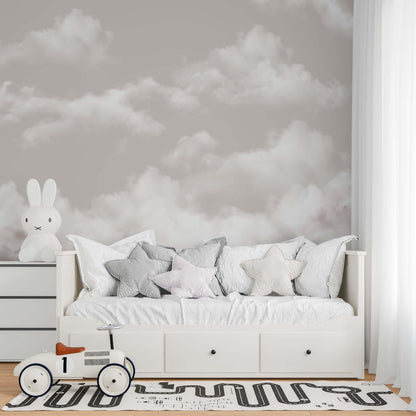 A tranquil bedroom scene with a white bed, cloud-themed wallpaper, and a fluffy white rug, enhancing the serene decor.