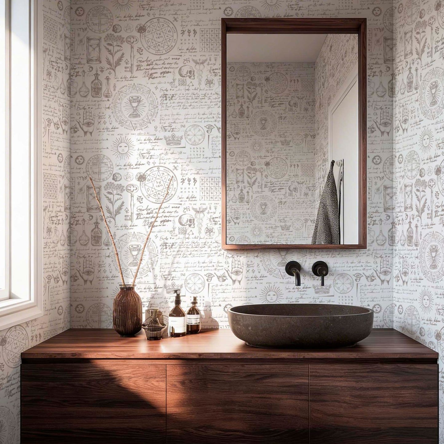 Vintage alchemy and apothecary themed wallpaper in a modern bathroom with a dark wood vanity, stone vessel sink, and botanical sketches.