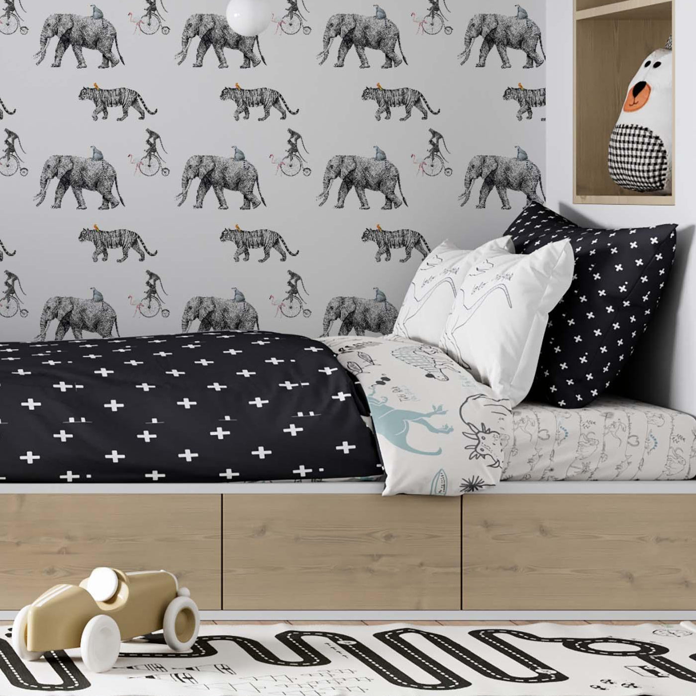 Black and white circus-themed wallpaper mural by Olively Home in a modern kids' room with a wooden platform bed and black cross-patterned bedding